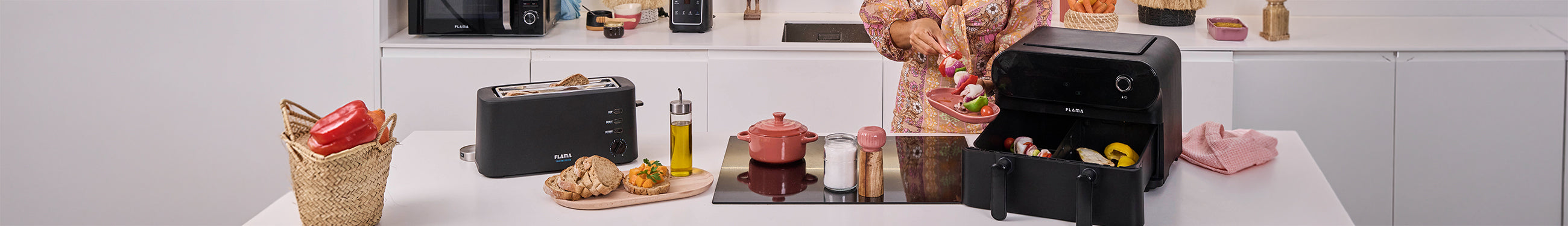 Mulher a preparar espetadas de legumes junto a uma air fryer preta de gaveta dupla da marca Flama numa bancada de cozinha
