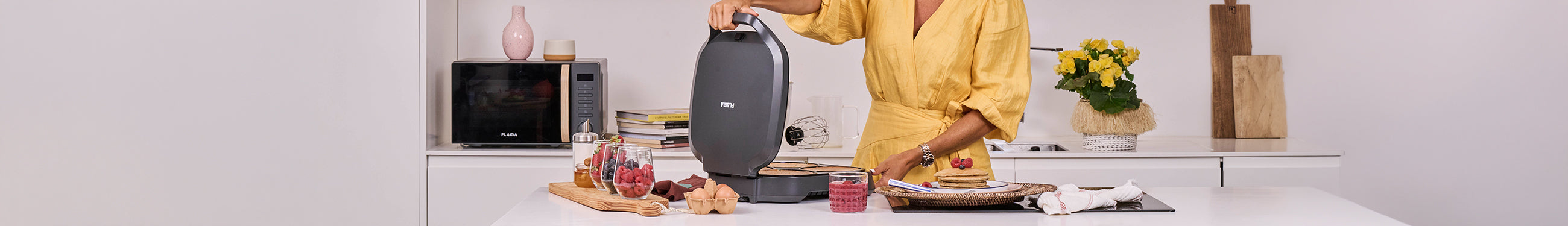 Mulher a abrir uma máquina de panqueca da Flama para preparar panquecas americanas numa cozinha moderna