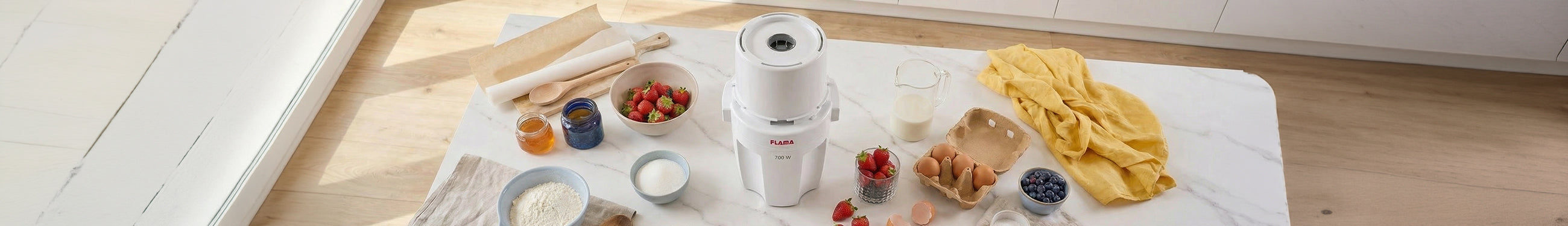 Picadora elétrica branca da marca Flama, disposta numa bancada de mármore rodeada de ingredientes frescos